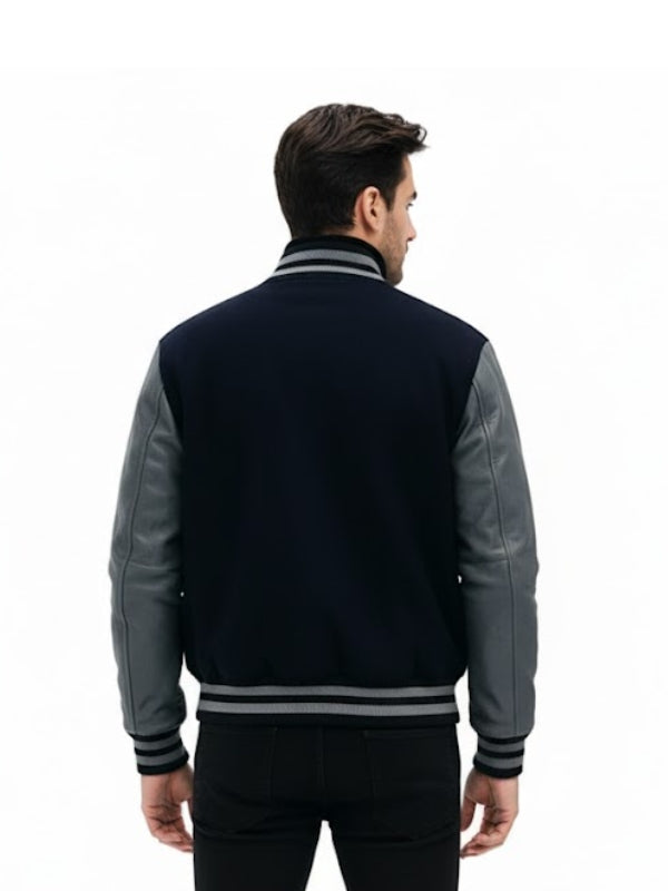 Man wearing a navy and gray varsity jacket on a white background