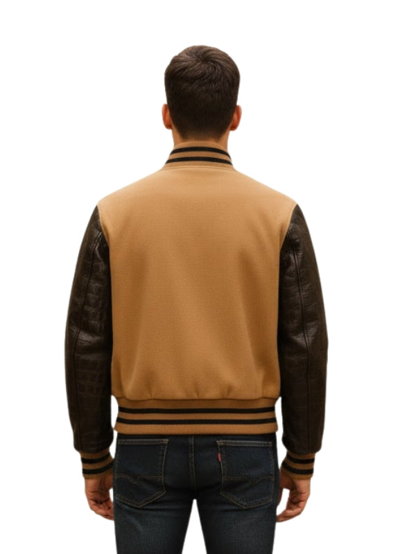 Man wearing a tan varsity jacket with black sleeves on a white background