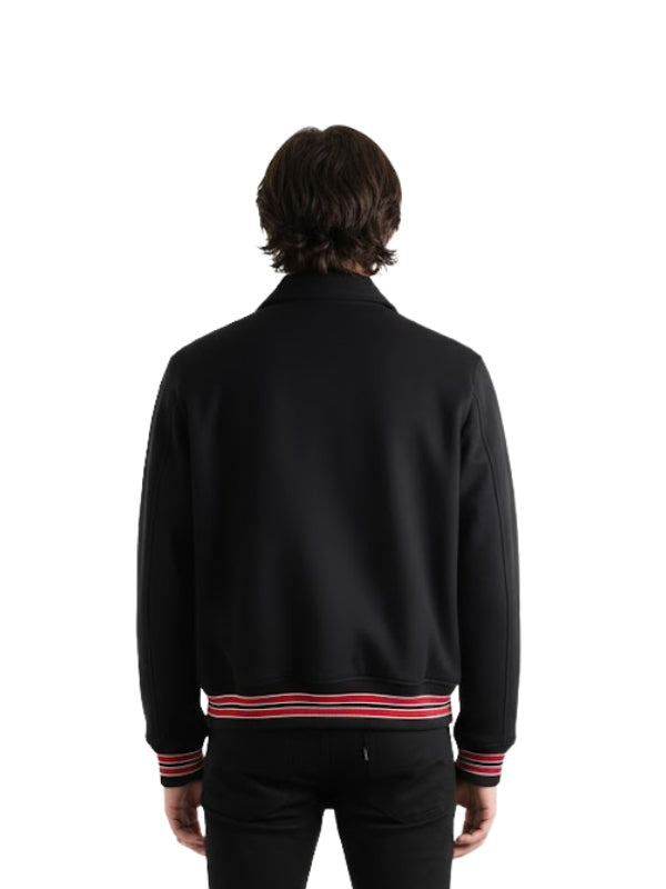 Person wearing a black jacket with red and white stripes on a white background