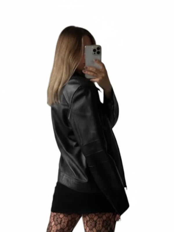 Person wearing a black leather jacket taking a mirror selfie on a white background