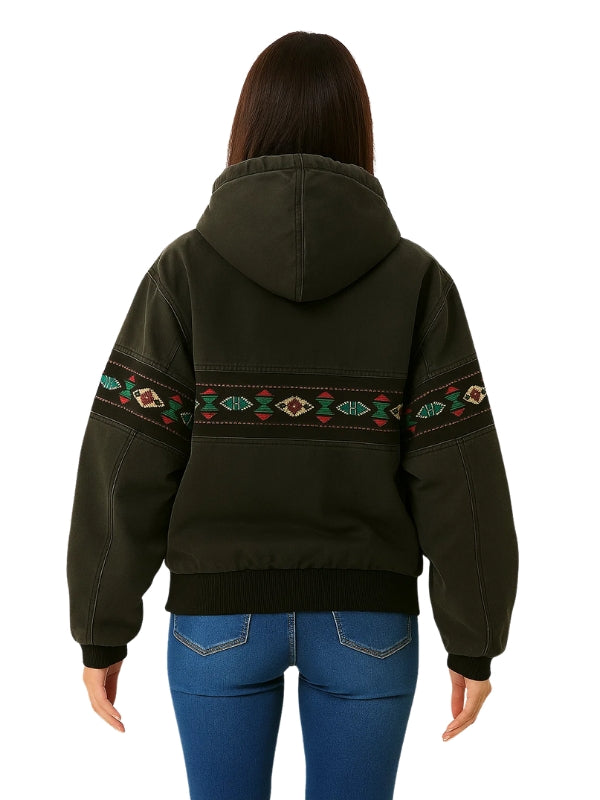 Person wearing a dark green hoodie with tribal patterns on the back, standing against a white background.