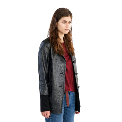 Woman wearing a black leather jacket over a red shirt on a white background