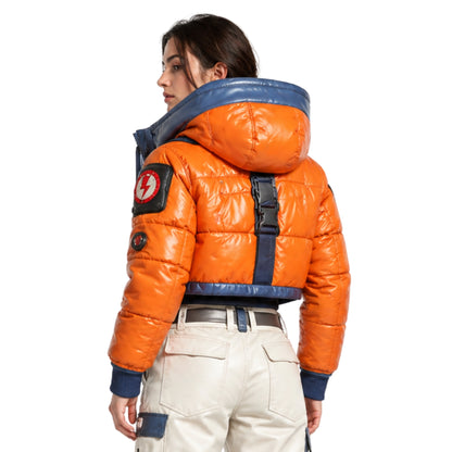Person wearing an orange puffer jacket with a blue hood on a white background