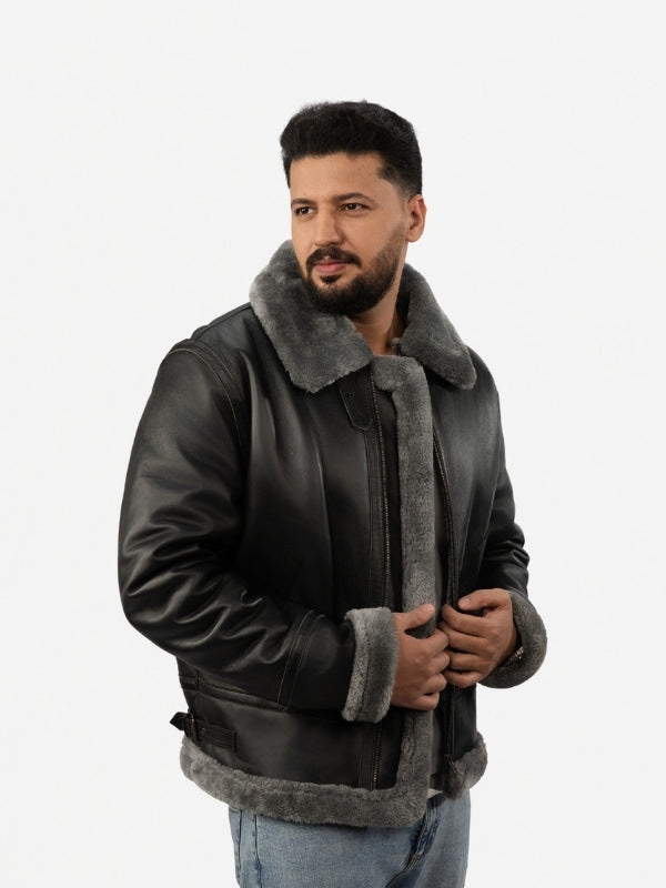 Man wearing a black leather jacket with gray fur lining on a white background