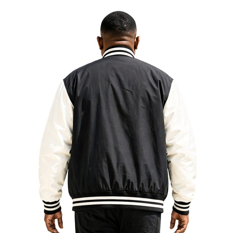 Person wearing a black and white varsity jacket on a white background