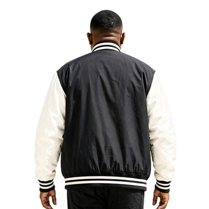 Person wearing a black and white varsity jacket on a white background