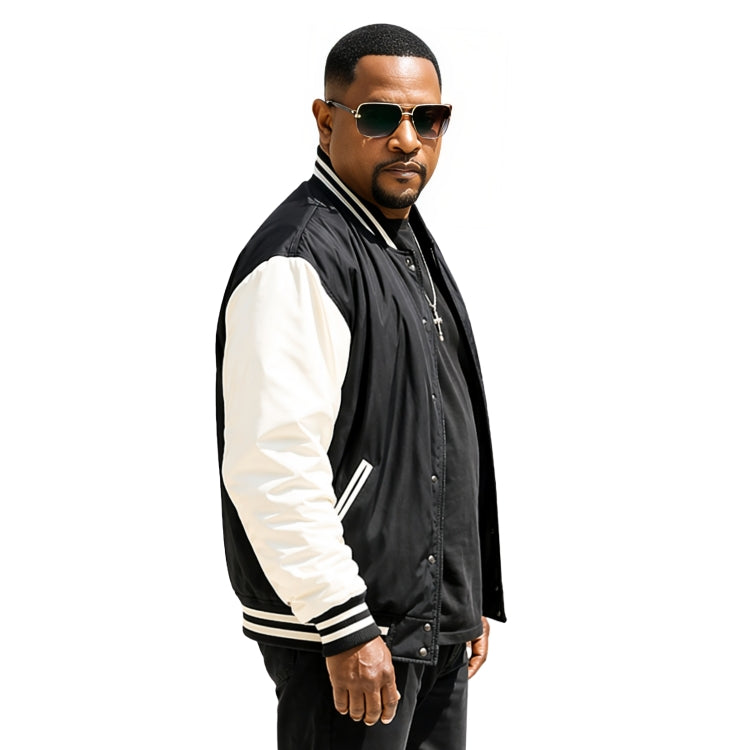 Man wearing a black and white varsity jacket with sunglasses on a white background