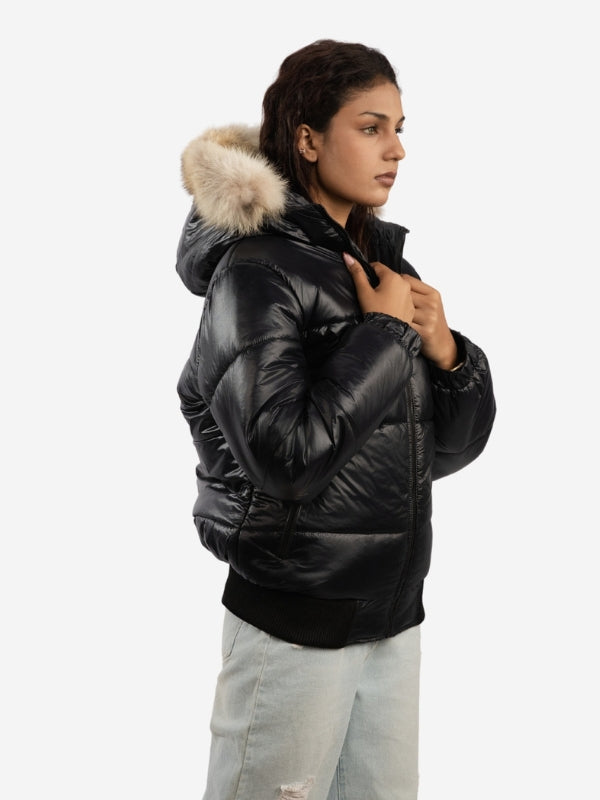 Person wearing a black puffer jacket with a fur-lined hood on a white background