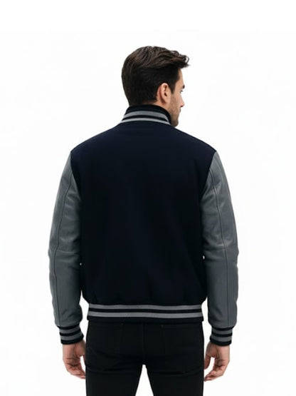 Man wearing a navy and gray varsity jacket on a white background