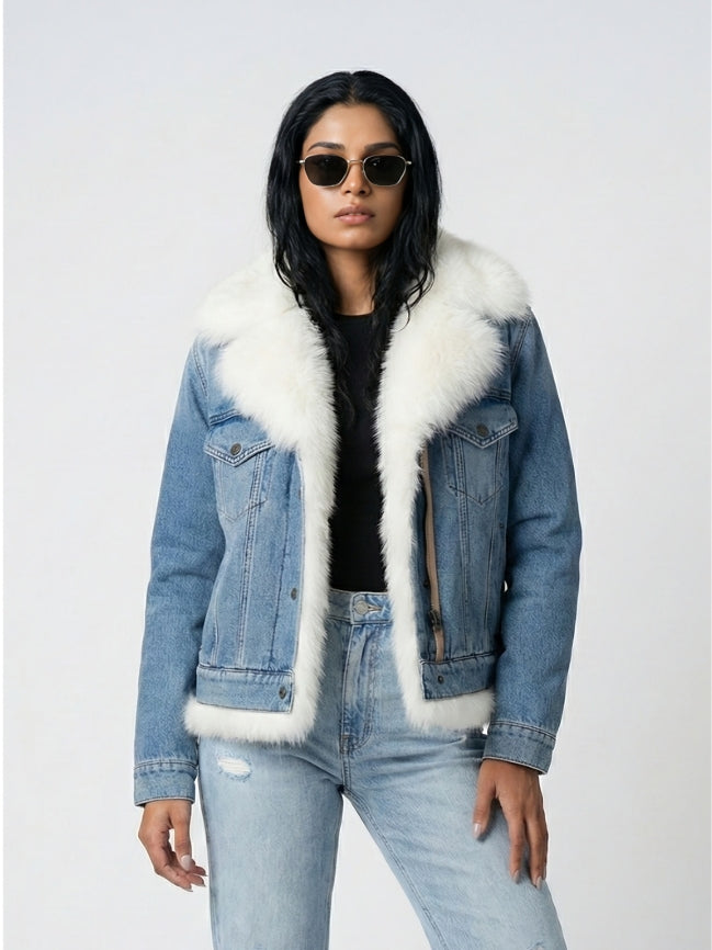 Person wearing a denim jacket with white fur trim on a light gray background