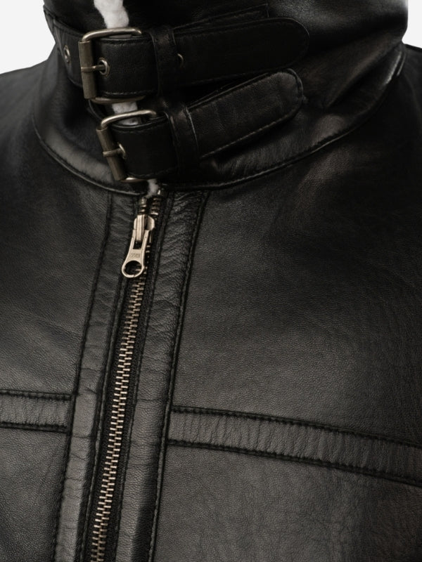 Close-up of a black leather jacket with a zipper and buckle detail.