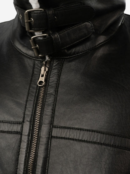 Close-up of a black leather jacket with a zipper and buckle detail.