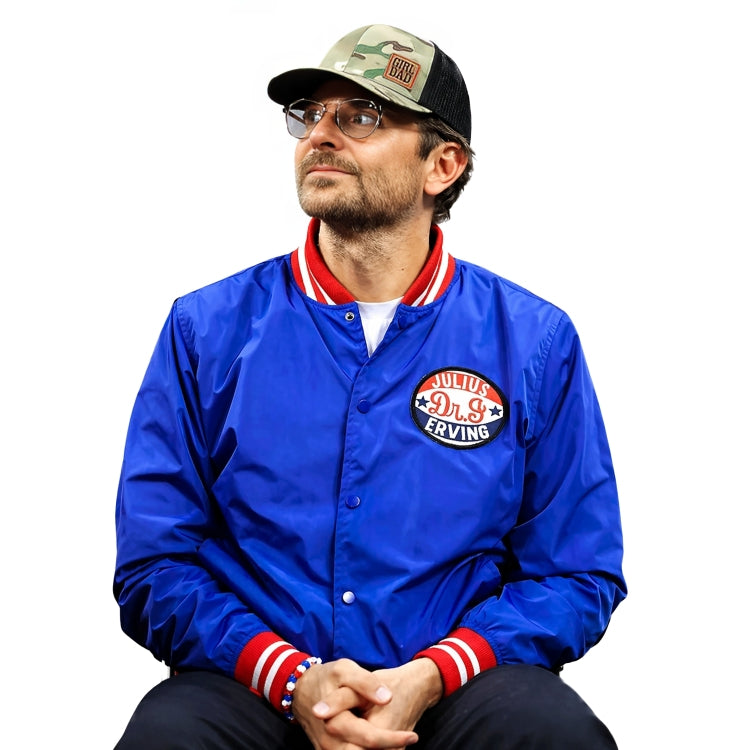 Man wearing a blue jacket with a logo, cap, and glasses on a white background