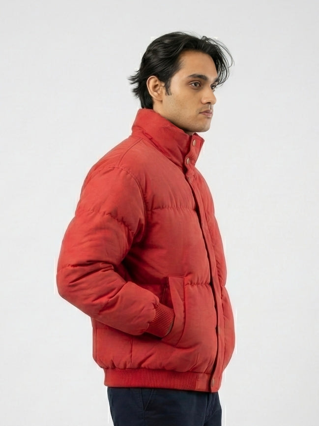 Man wearing a red puffer jacket against a white background