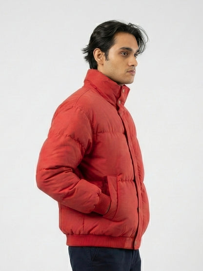 Man wearing a red puffer jacket against a white background