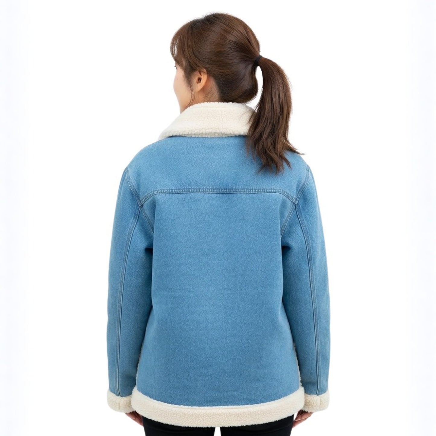 Person wearing a blue denim jacket with white fur trim on a white background