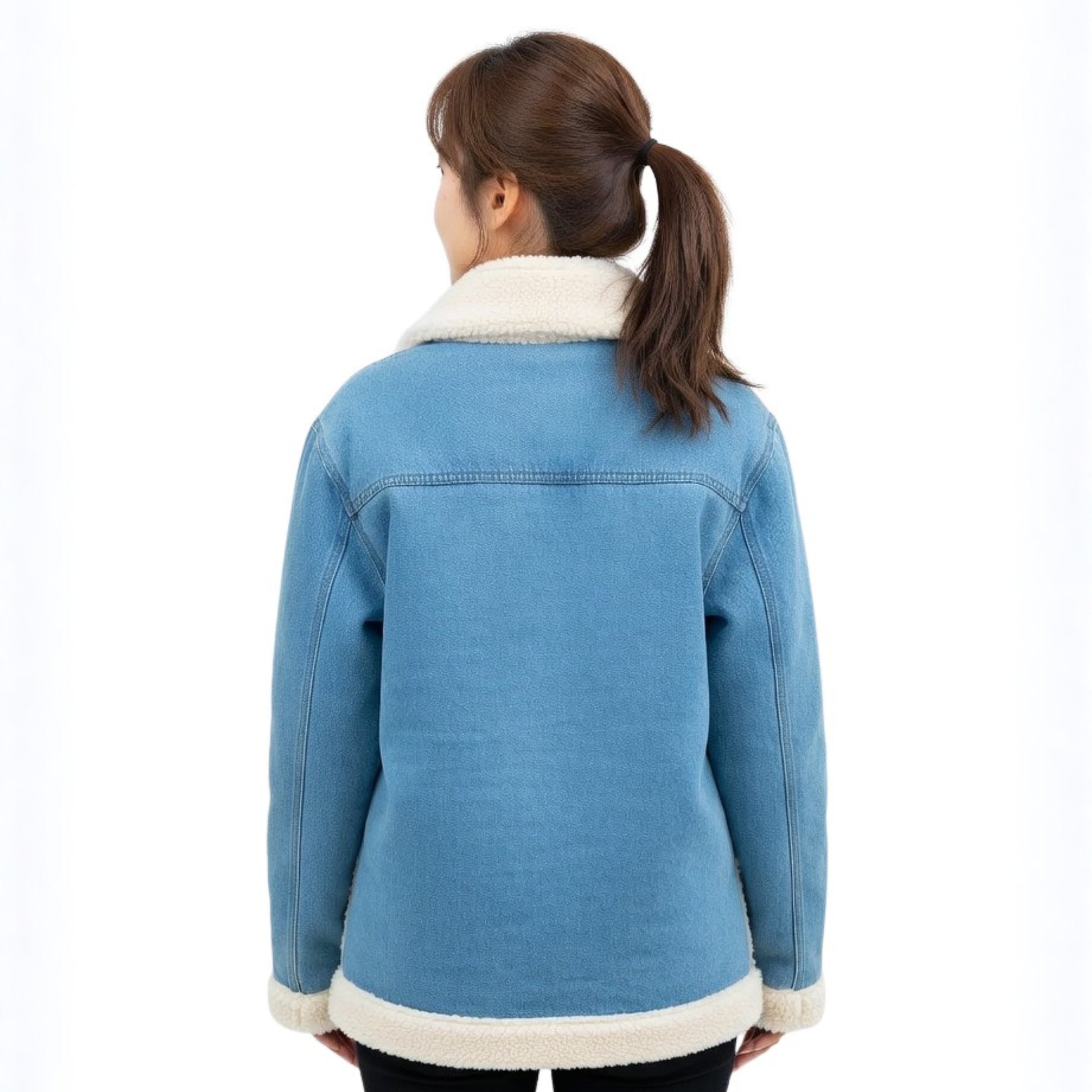 Person wearing a blue denim jacket with white fur trim on a white background