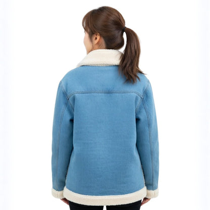 Person wearing a blue denim jacket with white fur trim on a white background