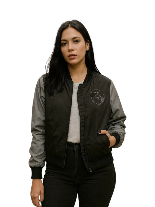 Woman wearing a black and gray bomber jacket with a logo on a white background