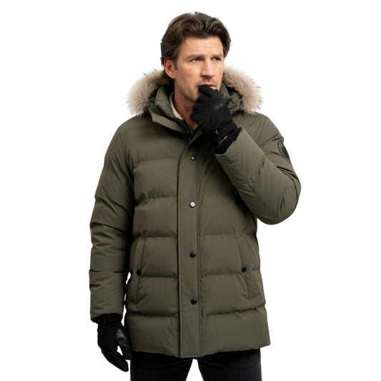 Man wearing a green winter coat with a fur-lined hood on a white background