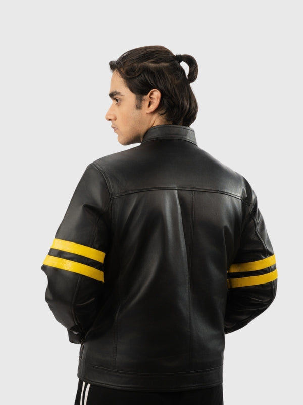 Person wearing a black leather jacket with yellow stripes on sleeves against a white background