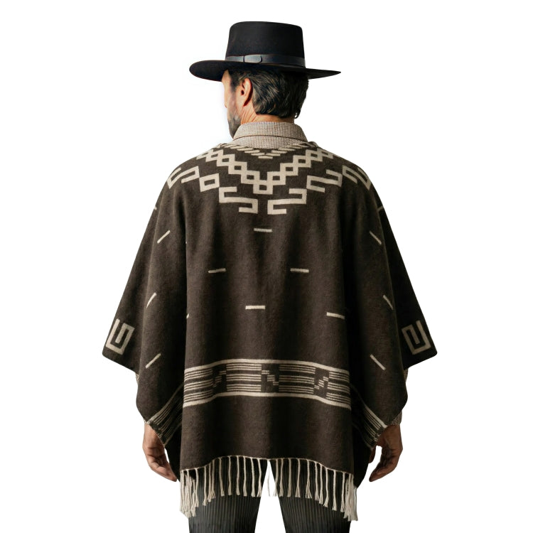 Person wearing a brown patterned poncho and black hat on a white background