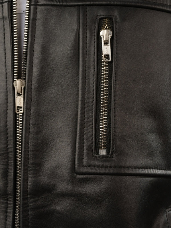 Close-up of a black leather jacket with gold zippers.
