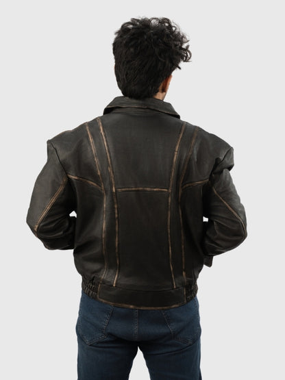 Person wearing a black leather jacket on a plain background