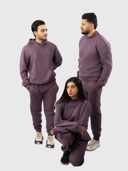 Three people wearing matching purple sweatsuits on a white background