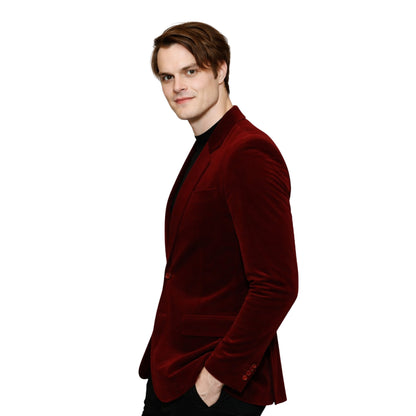 Man wearing a red velvet blazer on a white background