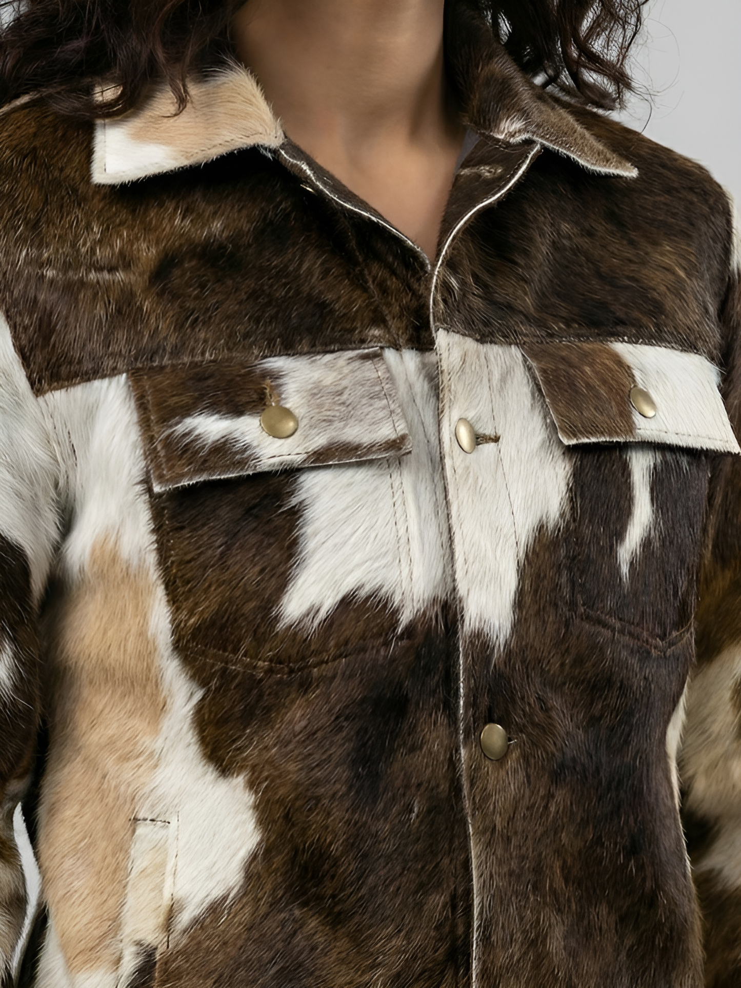 Close-up of a brown and white fur jacket with gold buttons.