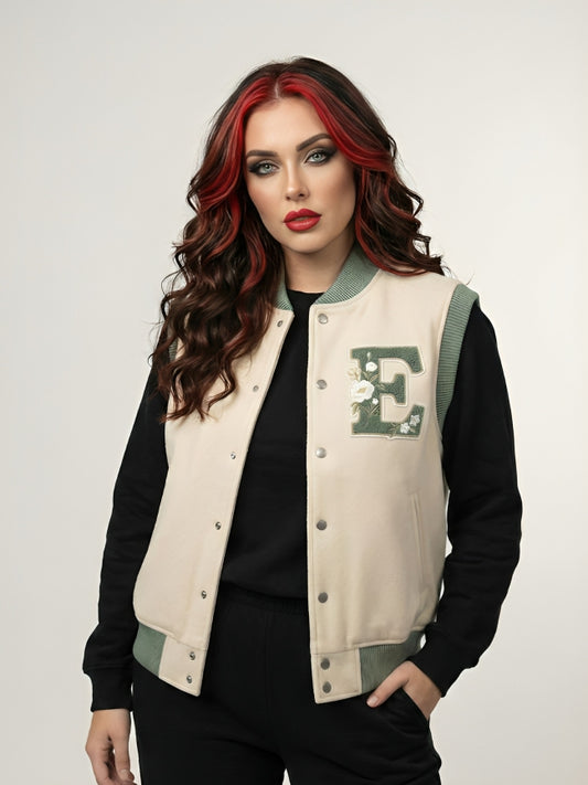 Woman wearing a beige letterman jacket with a green 'E' emblem on a white background