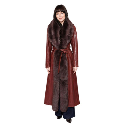 Woman wearing a long red coat with fur trim on a white background