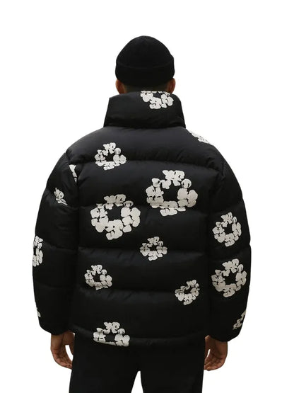 Denim Tears Wreath Black Puffer Jacket with bold logo and cozy fabric for warmth and style.