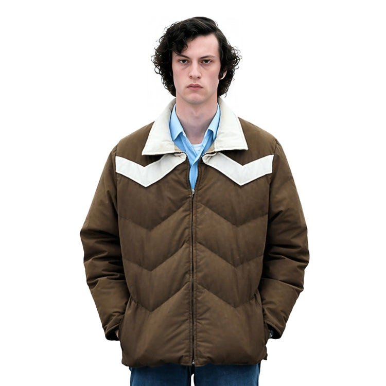 Person wearing a brown jacket with white collar and blue shirt on a white background