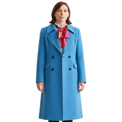 Woman wearing a blue coat with a red scarf on a white background