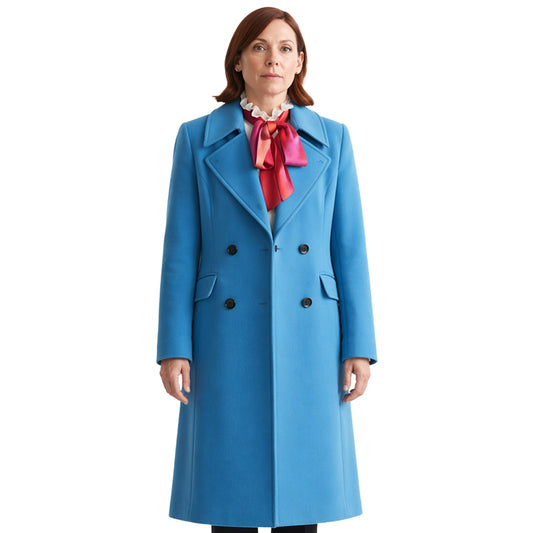 Woman wearing a blue coat with a red scarf on a white background