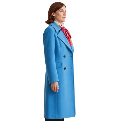 Woman wearing a blue coat with a red scarf on a white background