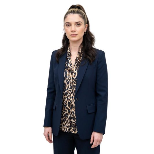 Woman wearing a navy blazer over a leopard print top on a white background