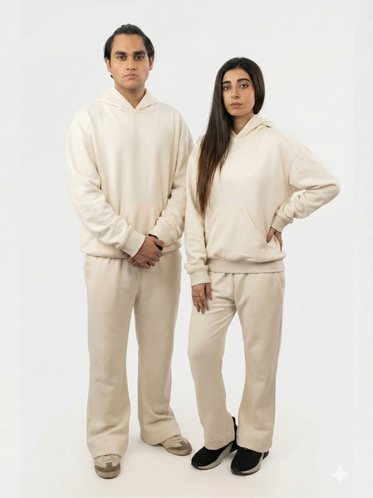 Two people wearing matching beige outfits on a white background