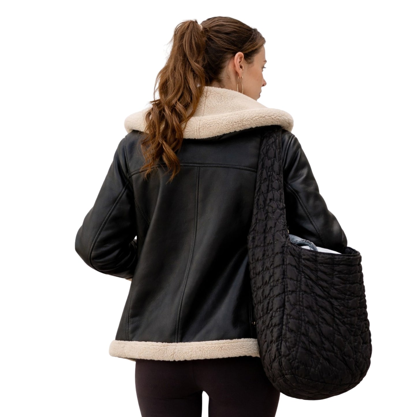 Woman wearing a black leather jacket with beige fur collar holding a textured black bag on a white background