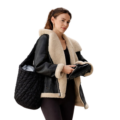 Woman holding a black quilted bag and a black leather jacket with beige shearling collar on a white background