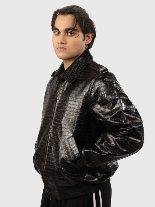 Man wearing a black crocodile-patterned leather jacket on a white background