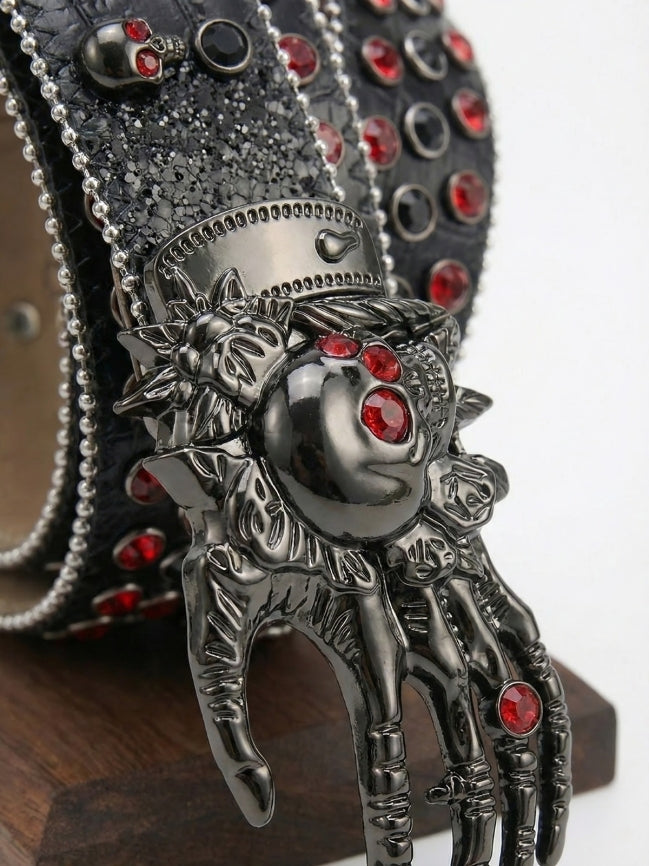 Decorative belt buckle with intricate design and red gemstones on a white background