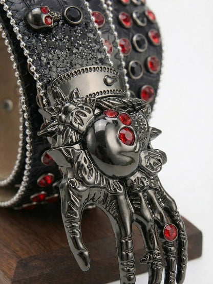 Decorative belt buckle with intricate design and red gemstones on a white background
