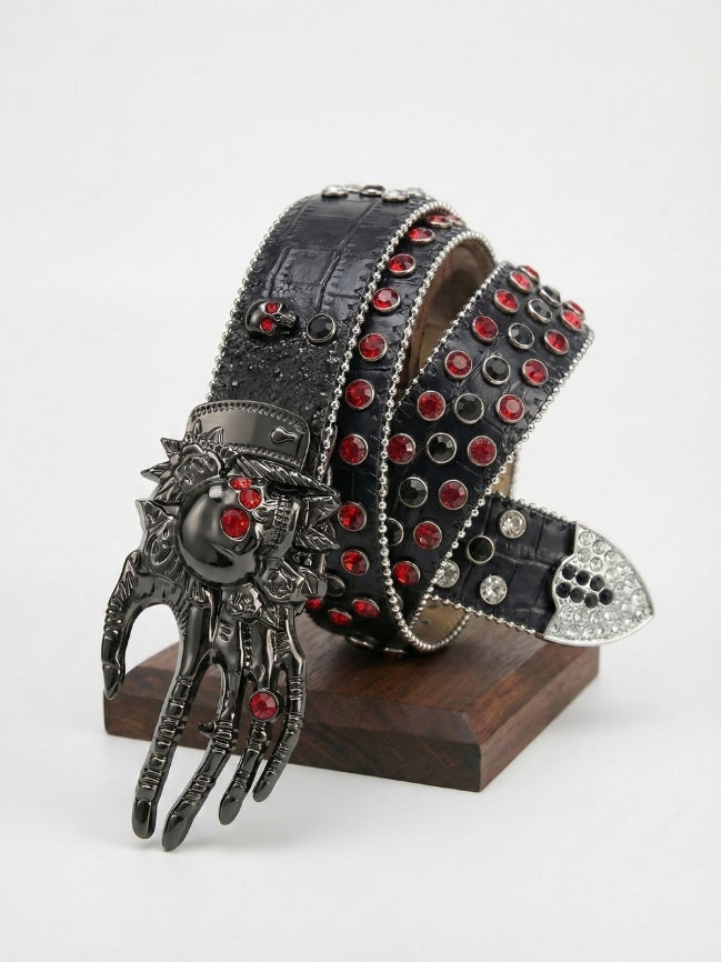 Decorative belt with red gemstones and a hand-shaped buckle on a stand against a white background
