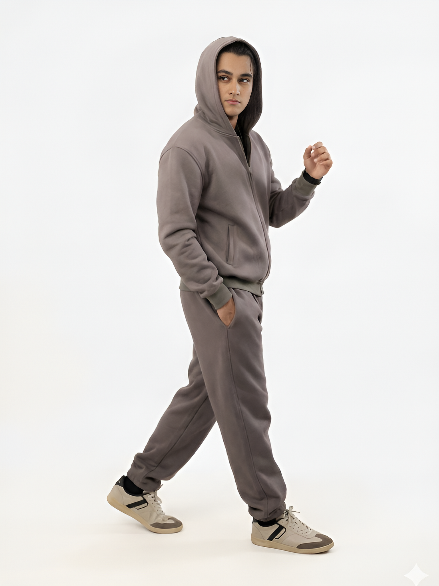 Person wearing a gray hoodie and pants on a white background