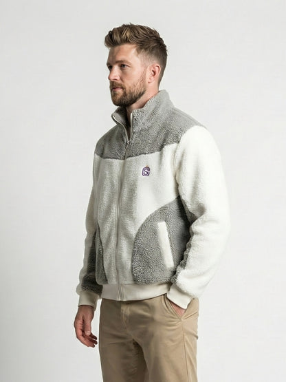 Man wearing a two-tone fleece jacket with a logo on a white background