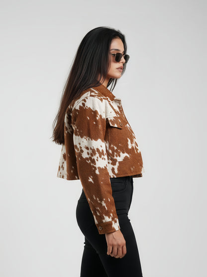 Woman wearing a brown and white cow print jacket on a white background