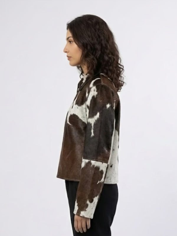 Person wearing a brown and white cow print shirt on a white background